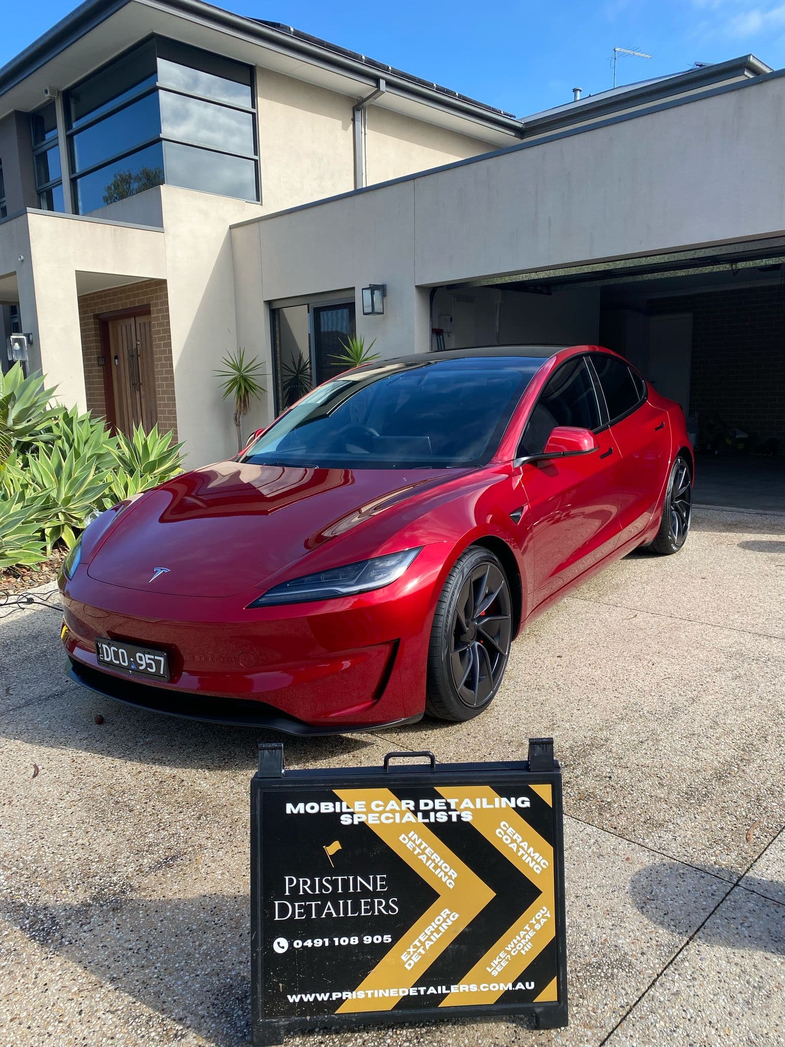 Paint protection film installation on a red Tesla